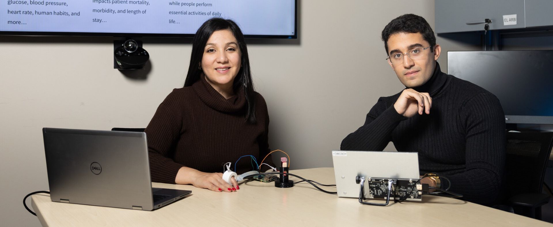 Two nuclear engineering students working with laptops and monitoring equipment.