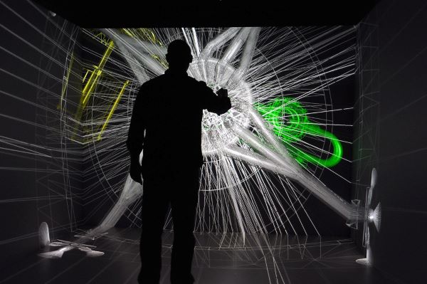 Silhouette of a person interacting with a 3D abstract digital visualization