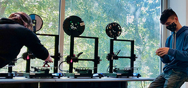 Students engaged in 3D printing activities inside the engineering building at KSU's 3D print farm.