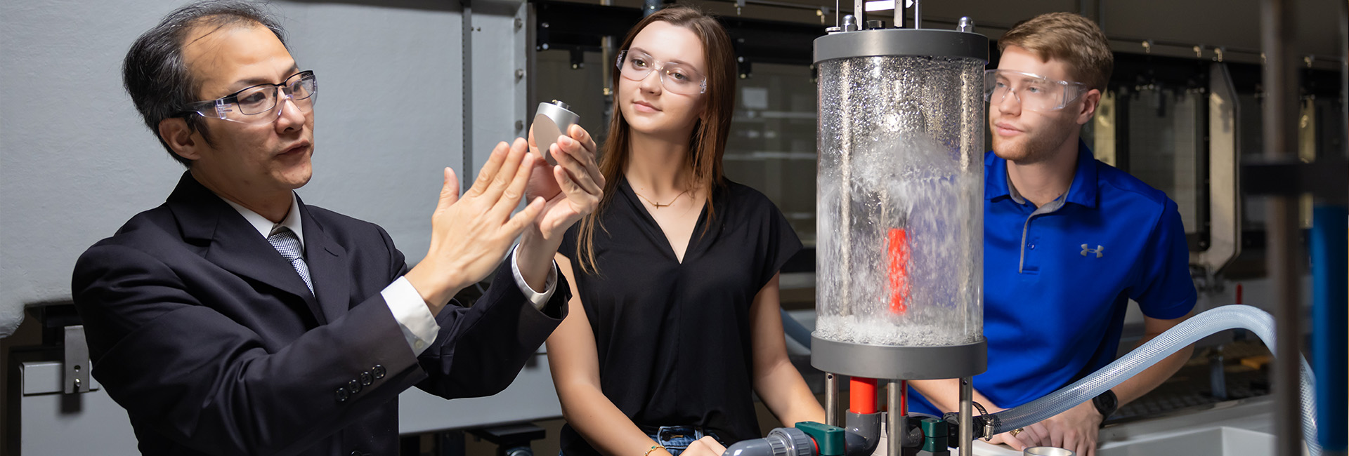 2 men and a woman in an engineering lab