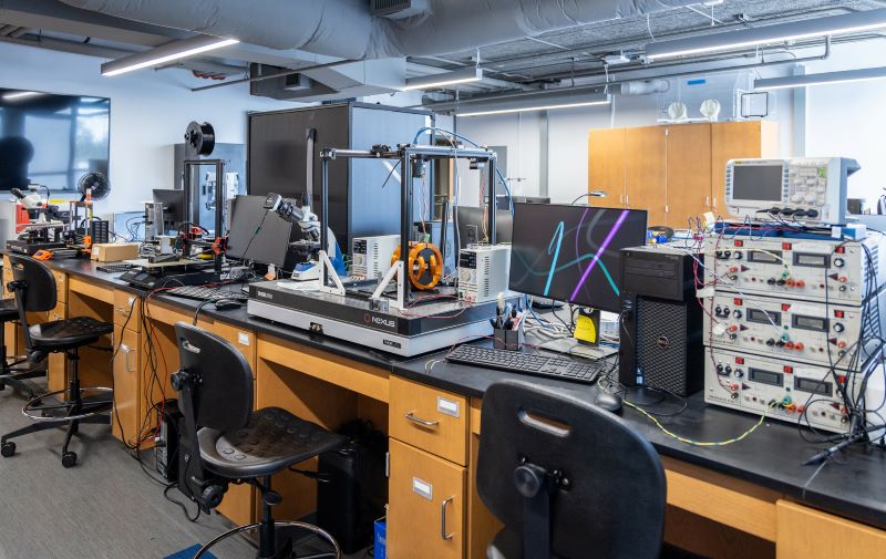 Engineering lab at KSU featuring workstations with 3D printers, oscilloscopes, and electronic equipment.