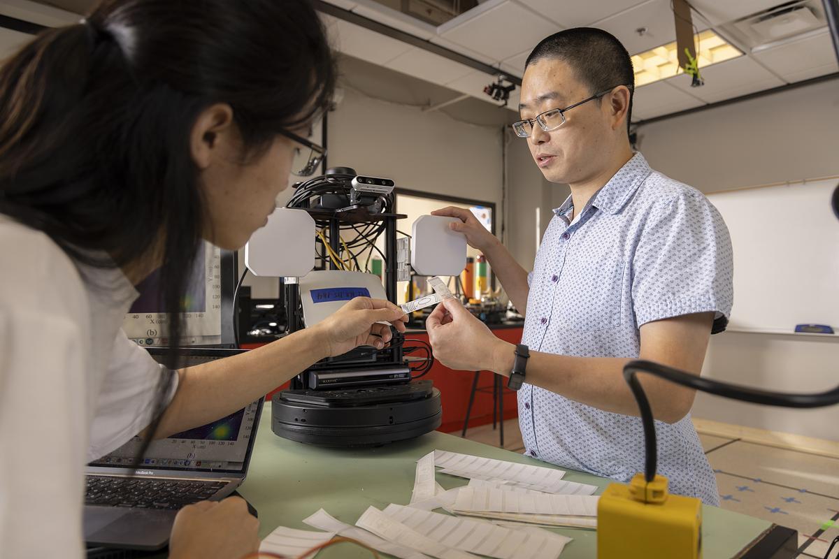 Two researchers in a lab at Kennesaw State University examining clothing tags as part of a study using AI to diagnose health issues.