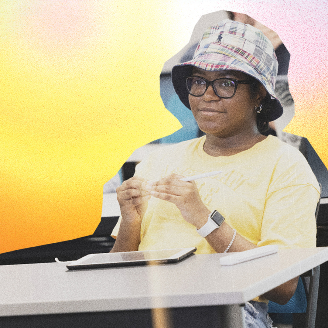 student in desk chair on a colorful background