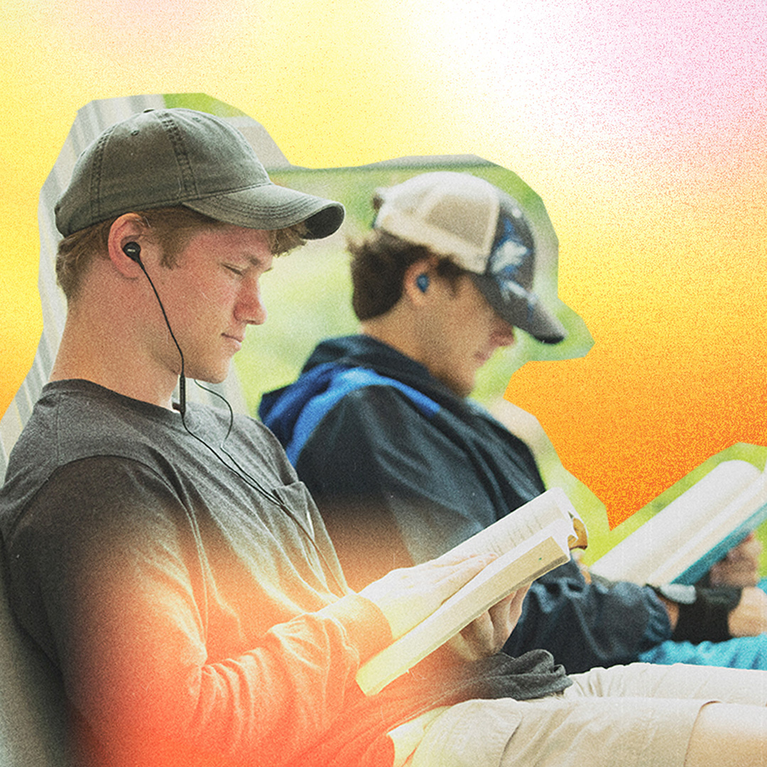 two students reading on bench on a colorful background