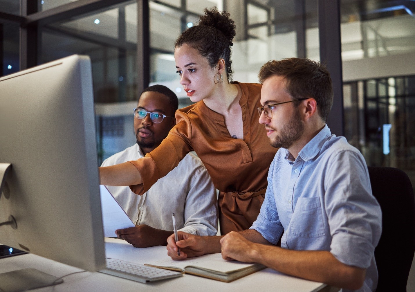 group of individuals working together looking at a computer screen