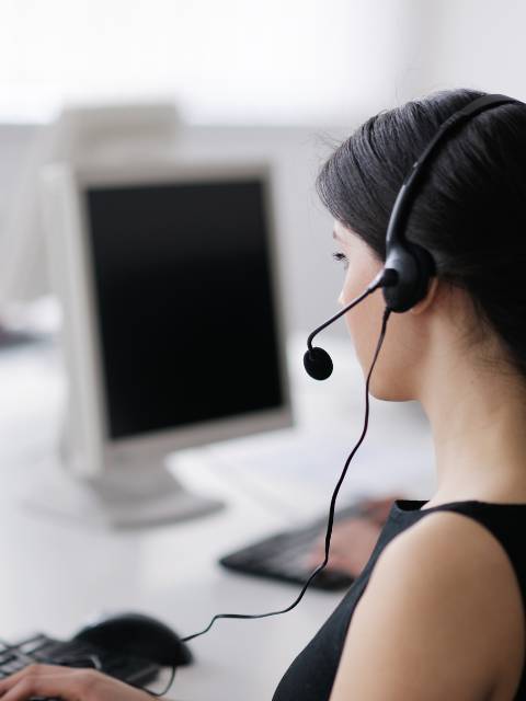 woman in headset sitting at office desk