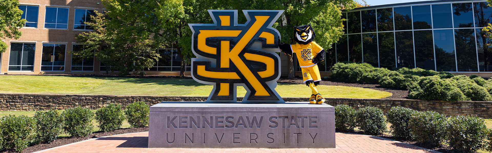 Scrappy standing in front of the KSU statue