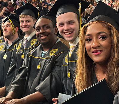 Spring 2024 graduates at the KSU Convocation Center Arena floor 