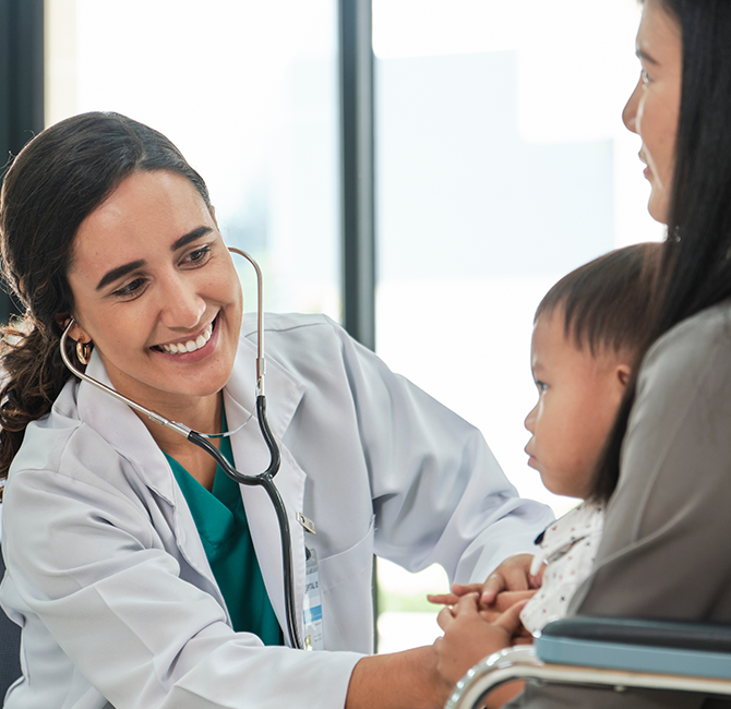 Young female pediatric doctor teases little Asian boy before medical examination at outpatient clinic hospital, people public health care checkups, and appointment