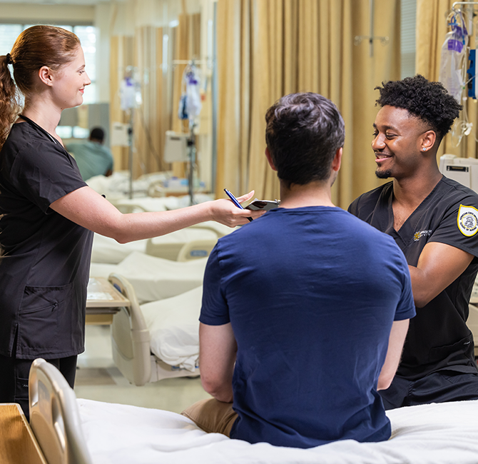 two dr with patient sitting on side of bed